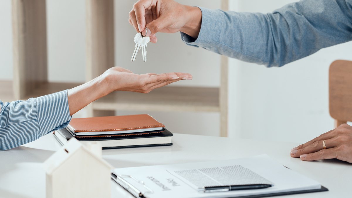Handing over apartment keys after signing a lease agreement.
